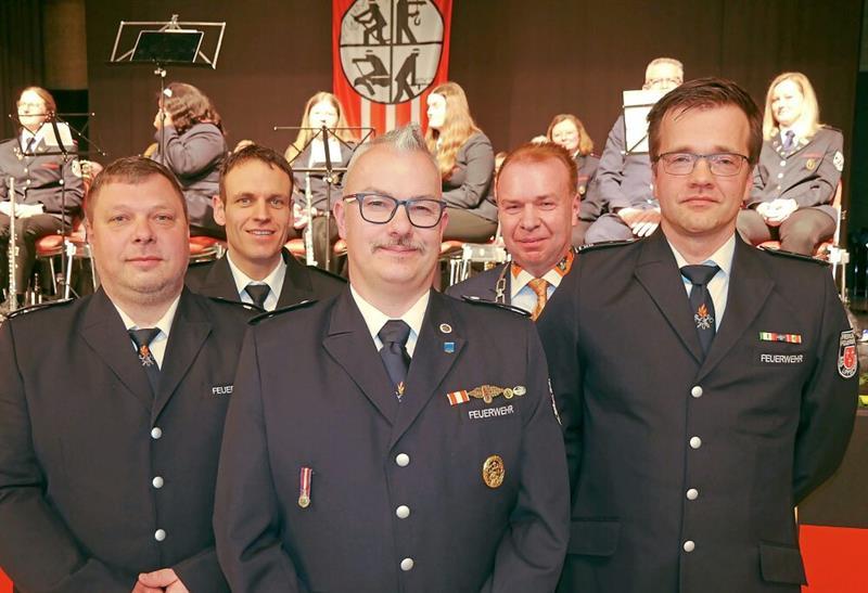 Glückwünsche für die neue Wehrführung mit (von links) Jörg Claes, Torsten Heggemann und Christian Hoffbauer. Zu den ersten Gratulanten gehörten (hintere Reihe von links) Kreisbrandmeister Stephan Reckhaus und Bürgermeister Ulrich Lange.